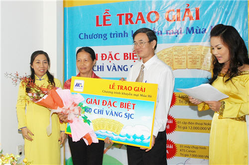 Ông Nguyễn Văn Hiển – Phó Tổng Giám đốc Nam A Bank và Bà Phạm Thị Huỳnh Mai Phó Giám đốc Nam A Bank Chi nhánh Tân Định trao quà và hoa cho khách hàng Nguyễn Thị Út trong chương trình Lễ Trao giải ngày 20/10/2010 